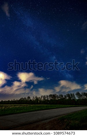 Partly cloudy in Ohio with the milky way positioned above farmland