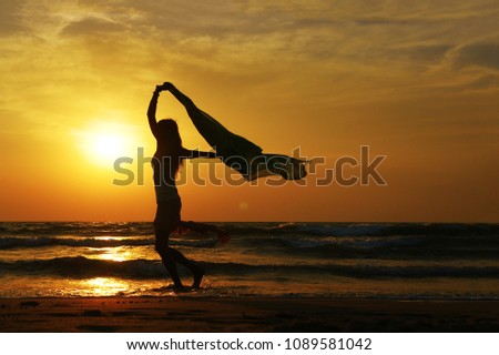 silhouette of a woman dancing on the beach