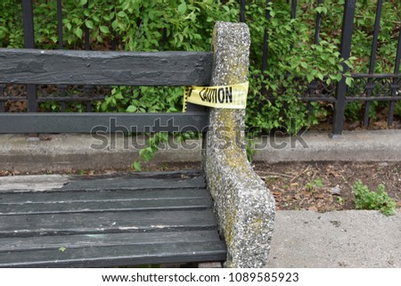 Caution tape around a park bench