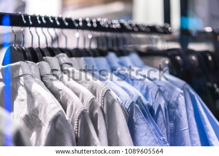 Clothes hang on a shelf in store