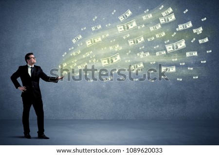 Caucasian male in business suit holding money,which flies through his hands