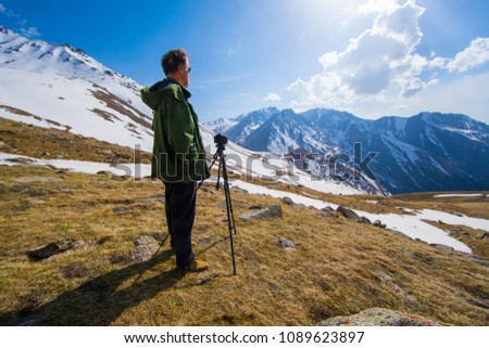 photographer traveler takes a mountain landscape,a camera on a tripod