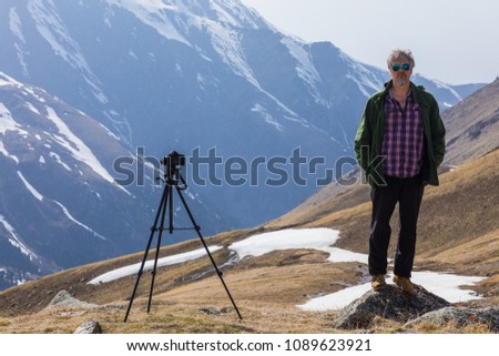 photographer traveler takes a mountain landscape,a camera on a tripod