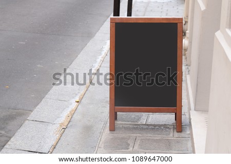 Blank cafe menu blackboard with copyspace on the street