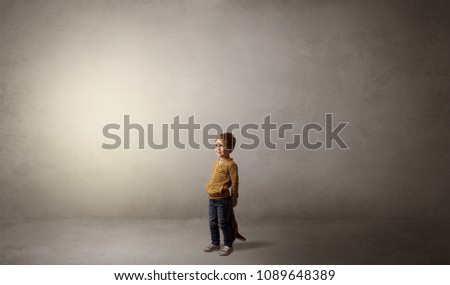 Little waggish kid staying alone in a big empty room with his plush