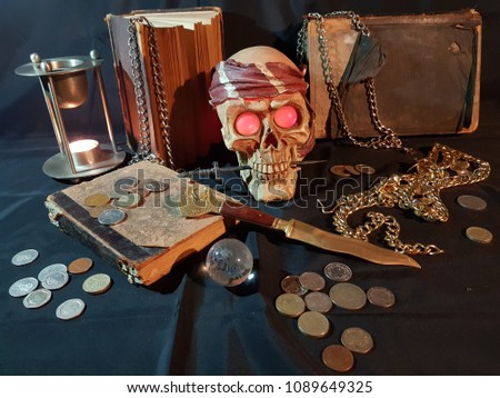 Still life, pirate skull with red eyes knife