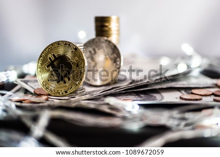 Bitcoin and dollar coins rotating on bills of 100 dollars