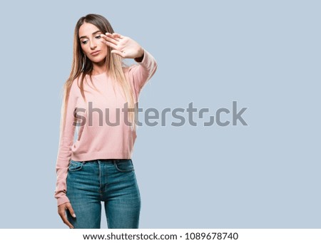 Young pretty woman serious and determined, putting hand in front, stop gesture, deny concept