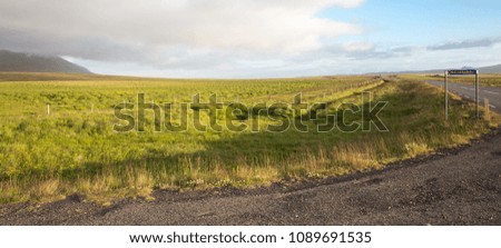 Melrakkadur road sign and green meadow with clear sunny weather in Iceland.