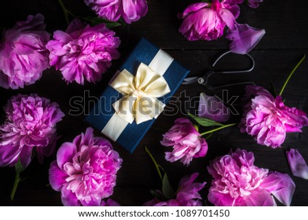 Gift box concept with pink peony flowers on rustic background with copy space
