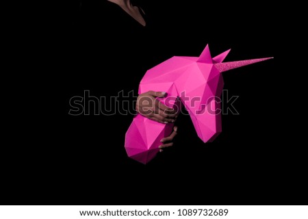 Hands hold a pink unicorn. Artwork. 3-inch Unique Paper Suit. Copy space