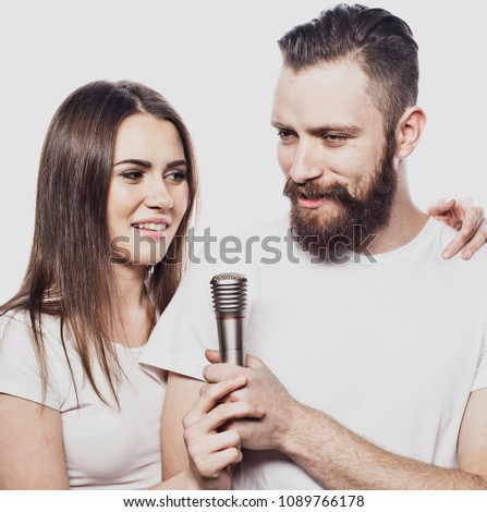 Happy couple singing in karaoke over white background, 