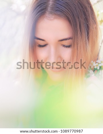 Portrait of young girl at the white spring flowers blossom