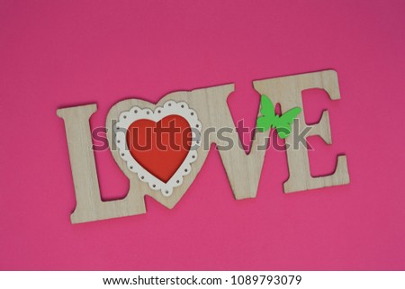 wooden love inscription with heart and butterfly, pink background