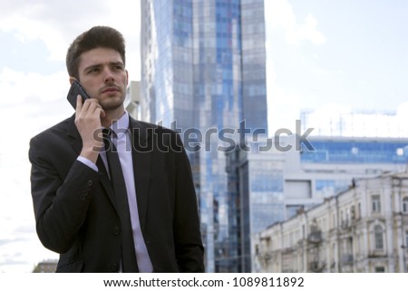 handsome young businessman in the big city talking on the phone