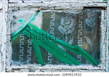 Background texture concept. Old cracked grungy window with green insulating tape and white curtains inside