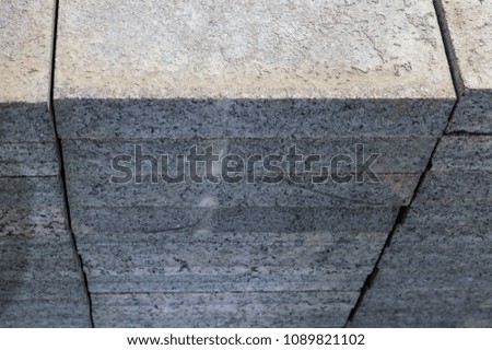 Concrete or granite gray square pavement slabs or stones for floor, wall or path stacked. Industry manufacturing or building concept