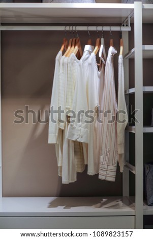 Image of light colored shirts hanging in the closet