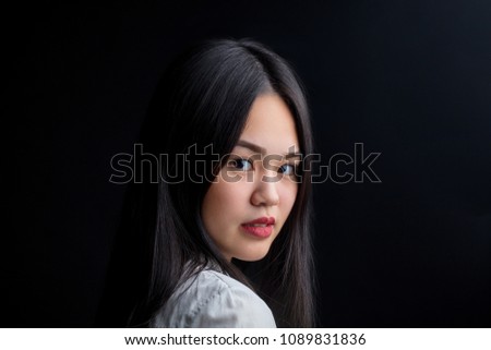 Close up of asian appealing woman in white shirt against black background