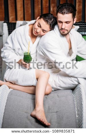 close up portrait of loving couple sitting in the resort in the white bathrobes. secure foothold concept