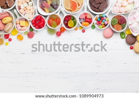 Colorful sweets. Lollipops, macaroons, marshmallow, marmalade, chocolate and candies. Top view with space for your greetings