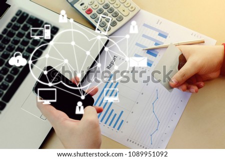 top view of hand holding smart phone and paying with credit card, chart report and calculator on desk at home office and graphic network icon, payment and shopping online, lifestyle technology concept