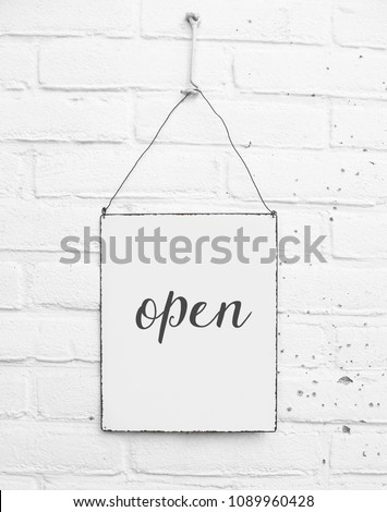 White square metal blank plate on white brick background with text Open - Come in - Welcome - mock up