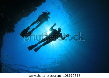 Couple Scuba Diving, silhouettes against sun
