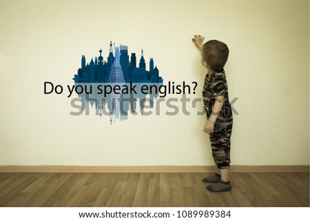 Language school. English lesson for children. the child in a military suit is standing in an empty room by the wall. and wrote an inscription on the wallpaper