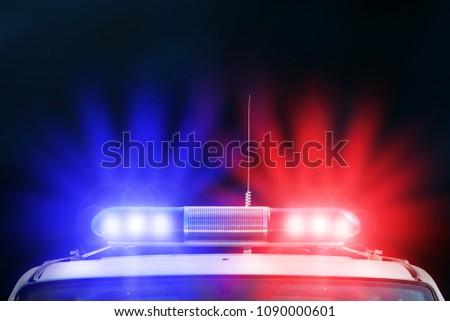Red and blue light flasher of a police car. Siren on police car flashing. Red and Blue flasher on the police car at night. Dark background.