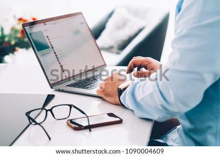 Closeup of businessman hands in blue shirt keyboarding email text message on modern pc computer at home interior table. Male work online via banking on laptop netbook. Office workspace with netbook Royalty-Free Stock Photo #1090004609