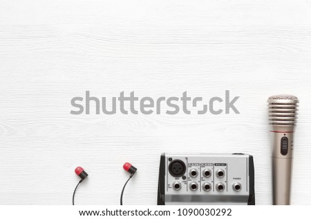 Audio recording studio desk table. Karaoke mock up. Song lyrics. Microphone, sound mixer and headphones on white wooden table background with copy space.