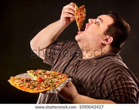 Diet failure of fat man eating fast food slice pizza on plate. Close up of breakfast for hungry overweight person who spoiled healthy food. He can not give up harmful food.