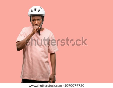 Black man wearing bike helmet sick and coughing, suffering asthma or bronchitis, medicine concept