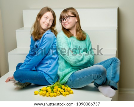 Two cute little girls close-up, in the studio on a white background. The concept of a happy childhood, Beauty and fashion. Isolated.