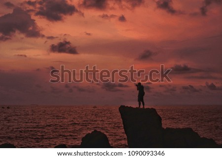 Silhouette Photographer on twilight red sky background in Thailand.