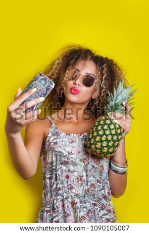 Beautiful Girl selfie with a smartphone. Beautiful young African American woman with afro hairstyle and sunglasses