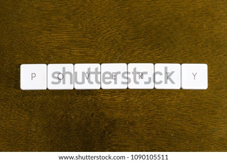 POVERTY word written on plastic keyboard alphabet with dark background