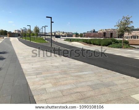 The quay of the city park is lined with granite, slabs and asphalt to separate the movement of pedestrians and cyclists.