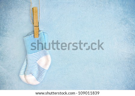 Blue baby socks on a textured rustic background with copy space Royalty-Free Stock Photo #109011839