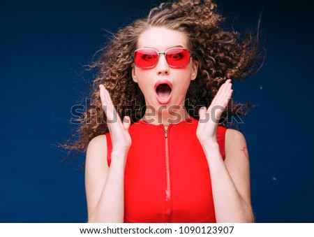 Red woman energy attractive fashion portrait with long curly hair and sun glasses