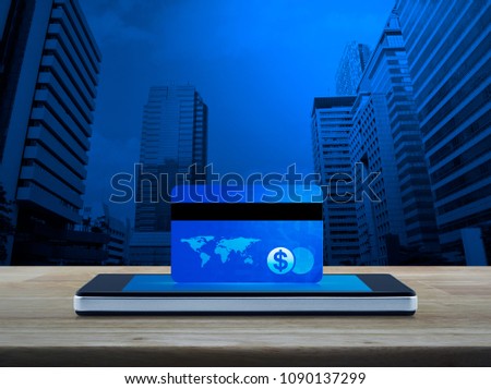 Blue credit card on modern smart phone screen on wooden table over modern city tower, Online e-payment concept, Elements of this image furnished by NASA