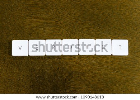 VERDICT word written on plastic keyboard alphabet with dark background