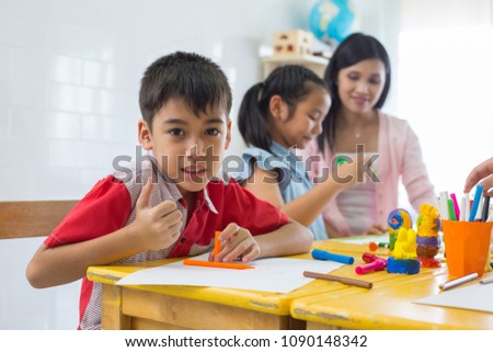 Asian student boy  learning art & painting at class room with thumb up feel good in school
