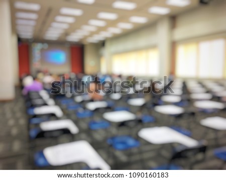 blurred image of empty large examination room with wooden chairs style. no people