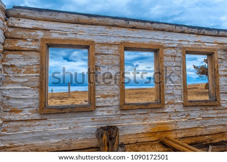 the ruins of a wooden house on the sandy beach of Baikal,