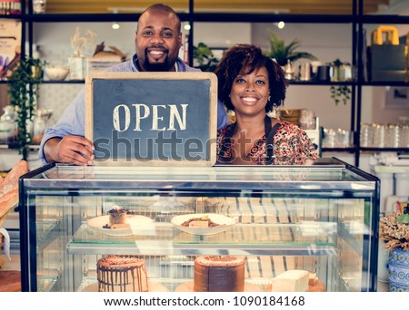 Cake cafe owners with open sign