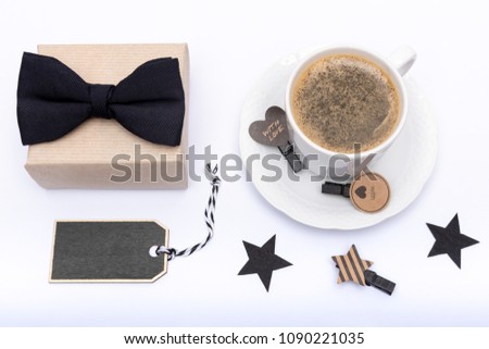Happy Father's Day Background. Cup of coffee, beautiful present and black bow tie on white background flat lay. Fathers day still life setup.