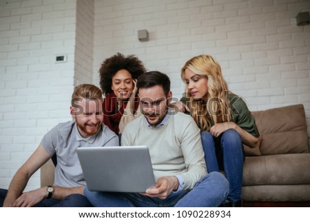 Group of young friends looking at a computer