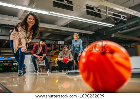 Shot of an attractive brunette throwing the bowling ball